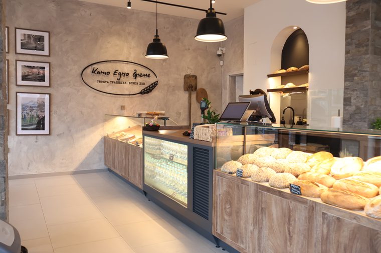 Interior of Kato Edno Vreme bakery in Sofia with counter, bread shelves and the hand-drawn logo on the wall